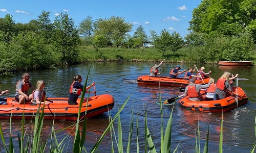 Gummibådsræs teambuilding aktivitet hvor hold samarbejder om at bygge og sejle en flåde.