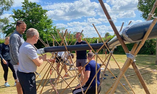 Pipeline teambuilding aktivitet hvor deltagere samarbejder om at transportere en bold gennem en rørbane.