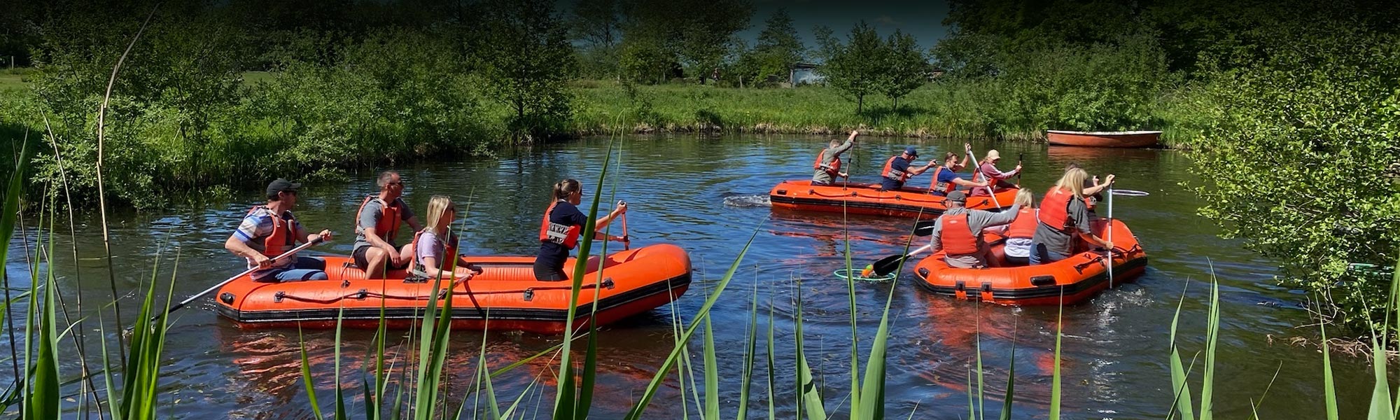 Gummibådsræs teambuilding aktivitet hvor hold samarbejder om at bygge og sejle en flåde