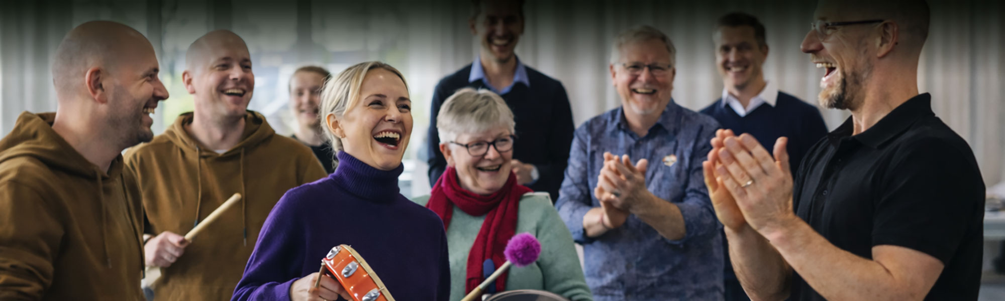 Musikalsk teambuilding hvor deltagere samarbejder om rytme og fælles musikalsk udtryk