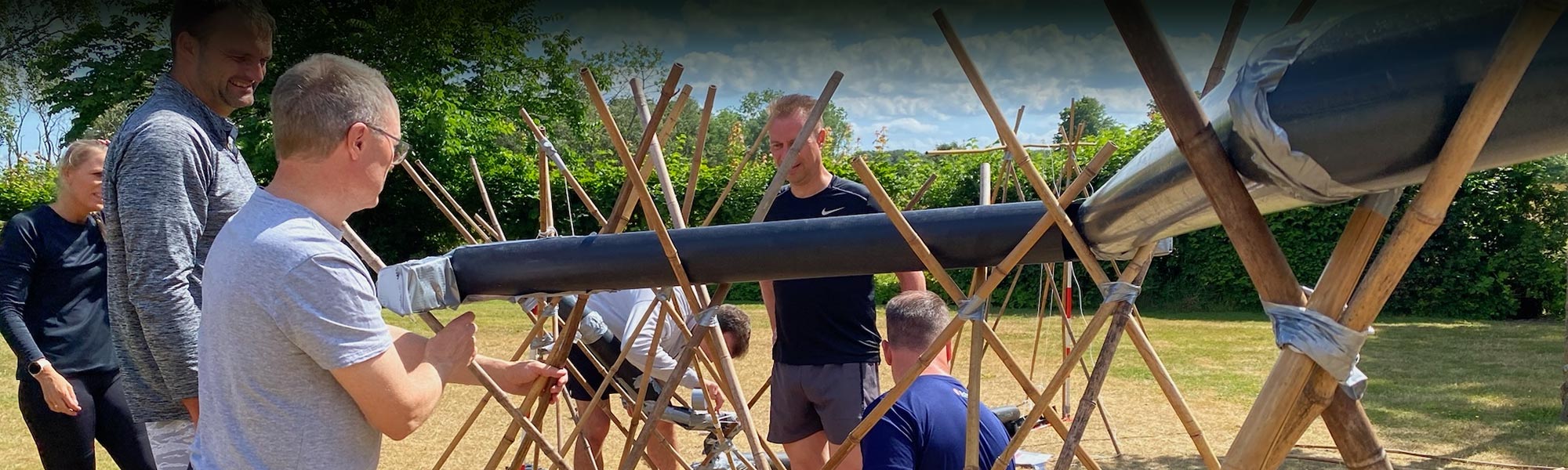 Pipeline teambuilding aktivitet hvor deltagere samarbejder om at transportere en bold gennem en rørbane.